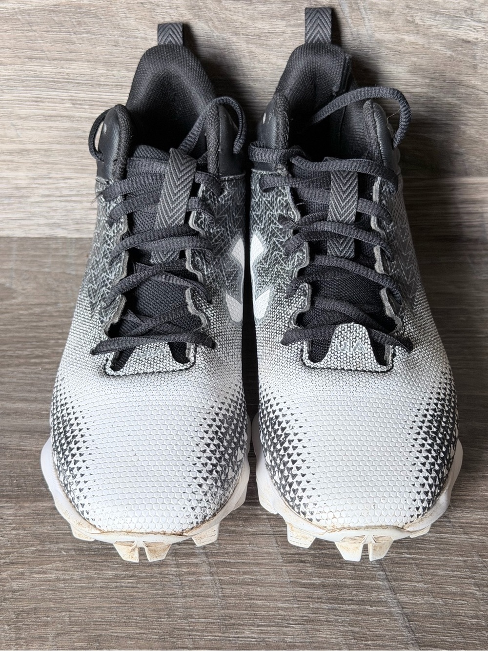Under Armour youth cleats in red and white with red-speckled white laces 2.5Y